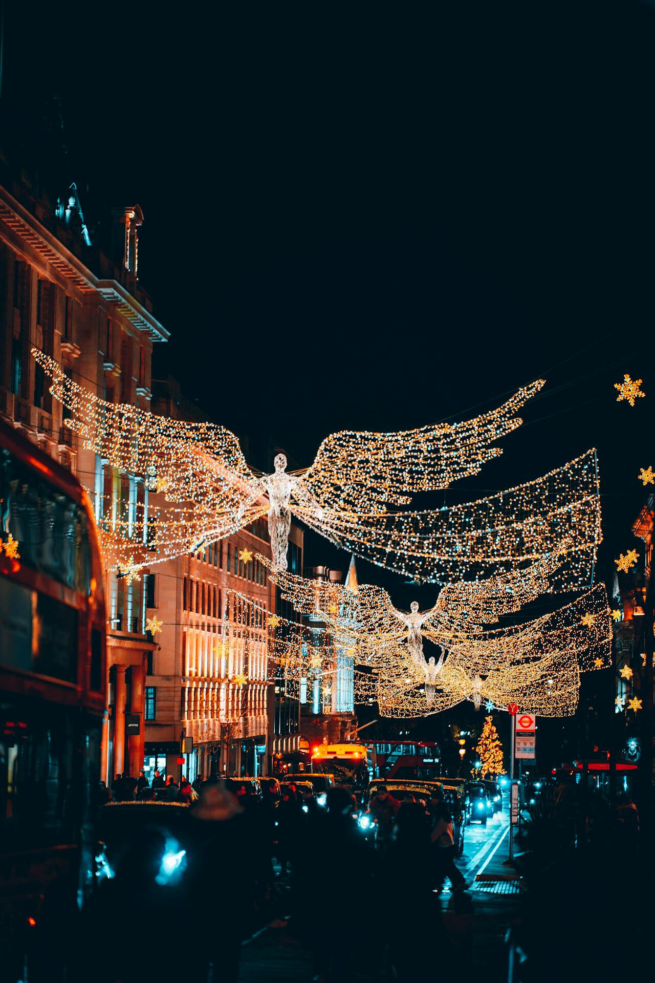 Χριστουγεννιάτικη μαγεία στη Regent Street του Λονδίνου, με φωτεινούς αγγέλους να αιωρούνται πάνω από τον πολυσύχναστο δρόμο γεμάτο κόσμο, λεωφορεία και γιορτινή ατμόσφαιρα.